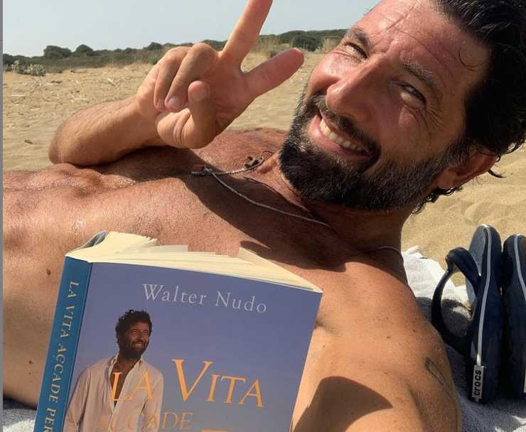 Walter Nudo in spiaggia con il suo nuovo libro (Instagram)